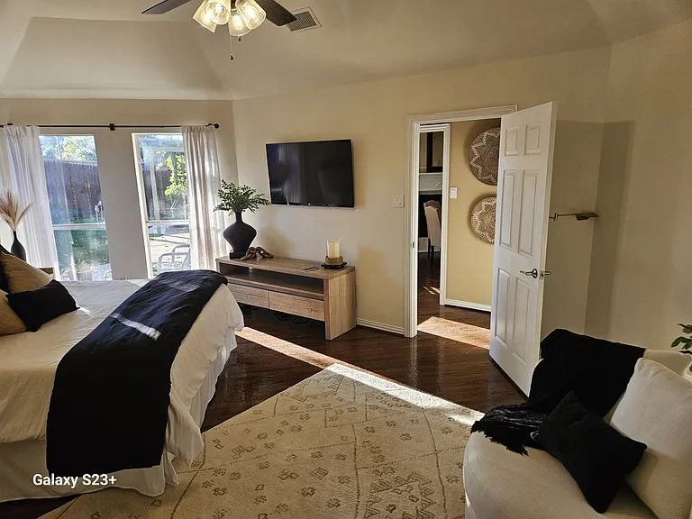 Another view of Master bedroom with included TV and view of patio and putting green.
