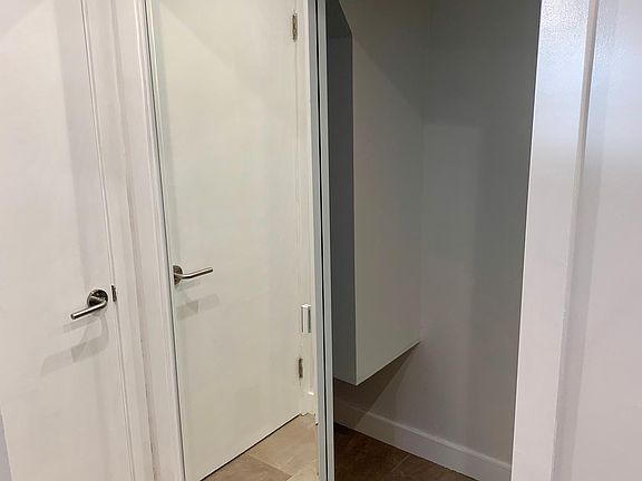 Additional storage closet in bathroom with full mirrored doors