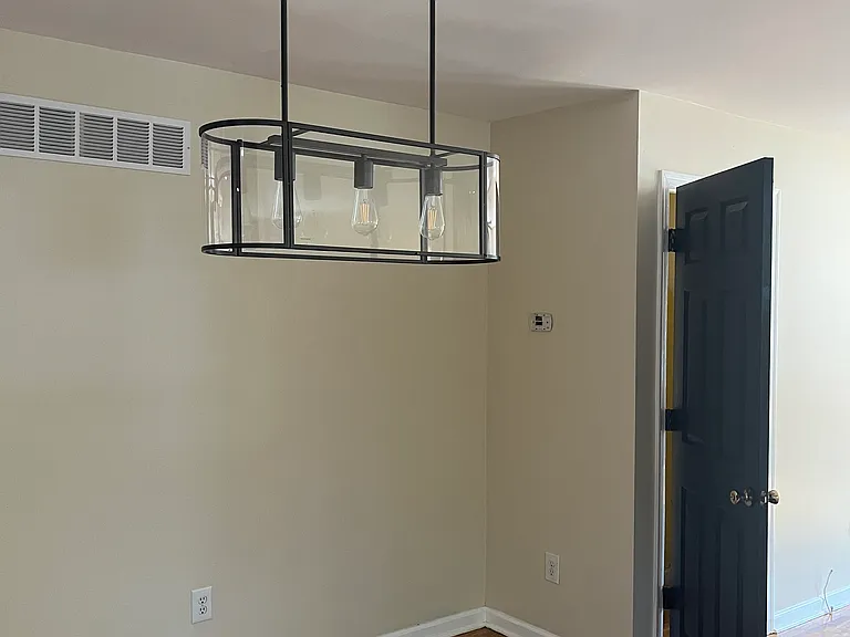 Modern light fixture for dining area. Door open is to the basement used only for storage.
