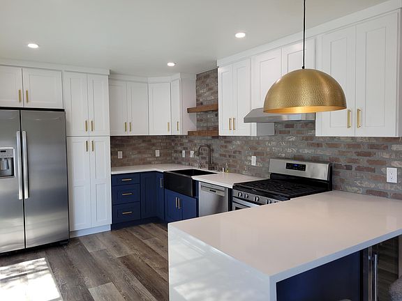 Tastefully remodeled kitchen. 24" wide pantry, farmhouse sink, open floating shelves from West Elm, gold handle hardware and dome lighting fixture!