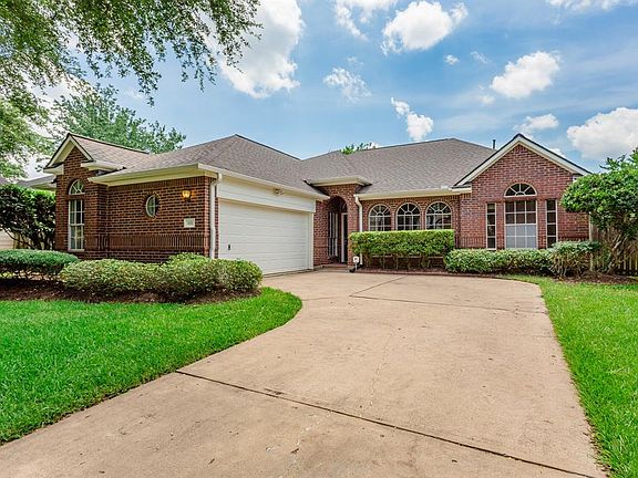 This home boasts a handsome brick elevation with arched windows and a covered arched porch and entry. The wide driveway leading to the two car garage offers plenty of off street parking for homeowners and guests. Recent roof and rain gutters.
