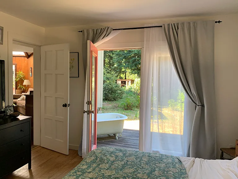 Main bedroom with view to outdoor tub on deck