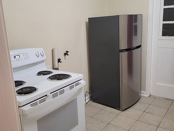Clean, like-new appliances. Gas Stove and Stainless Steel Refrigerator. There is a washer hookup in between.