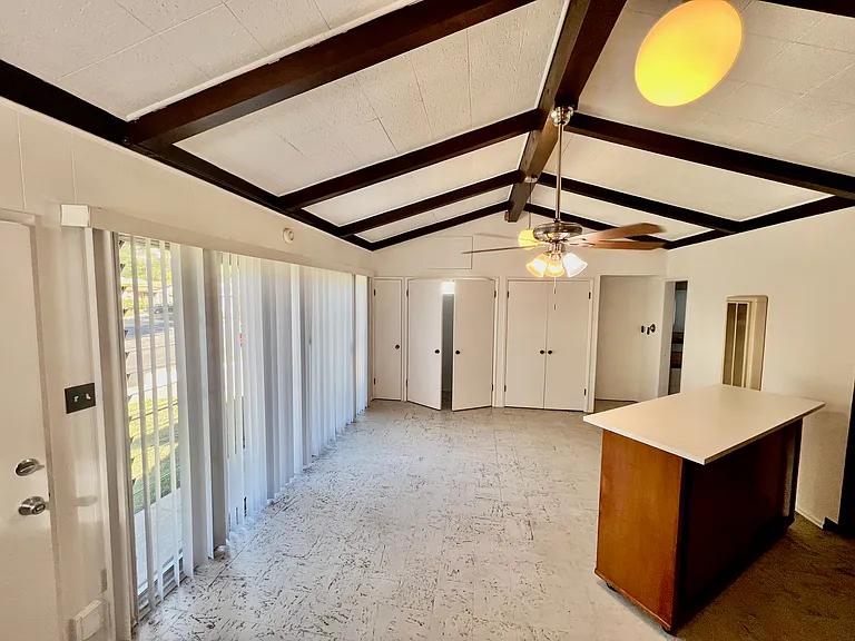 Studio Living/ sleeping area, closets, dining bar, front window (currently has light filtering drapes) front door entry