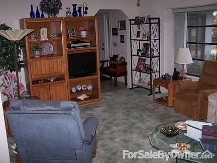East half of Living Room. : Large room next to vestibule with overhead fan. Window looks out front.