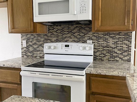 Stove and new microwave, note granite countertops and tile back splash.