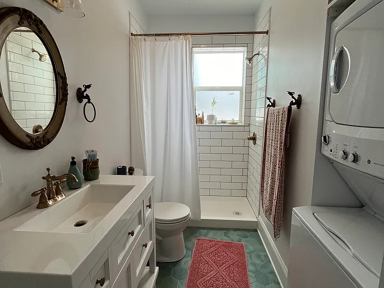 Functional bathroom with washer, dryer, and tons of shelving above the WD unit.