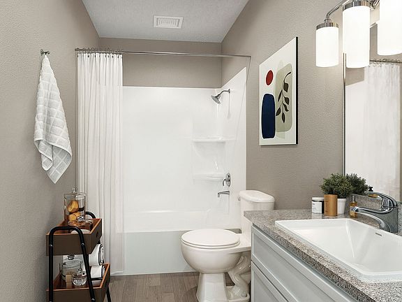 Bright bathroom with granite counters and bathtub
