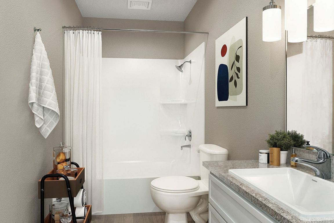Bright bathroom with granite counters and bathtub