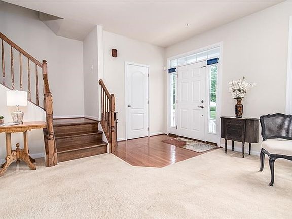 Inviting hardwood flooring entry way, offering a conveniently located powder room to the immediate right.  Custom, boxed oak sta