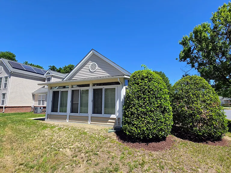 Premium rear exterior view showcasing the custom, fully enclosed sunroom bump-out designed for year-round enjoyment.