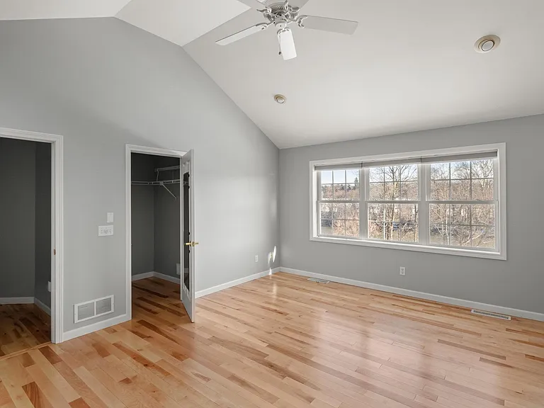 Primary bedroom with a view of the Winooski River. One of two primary bedroom walk-in closets.