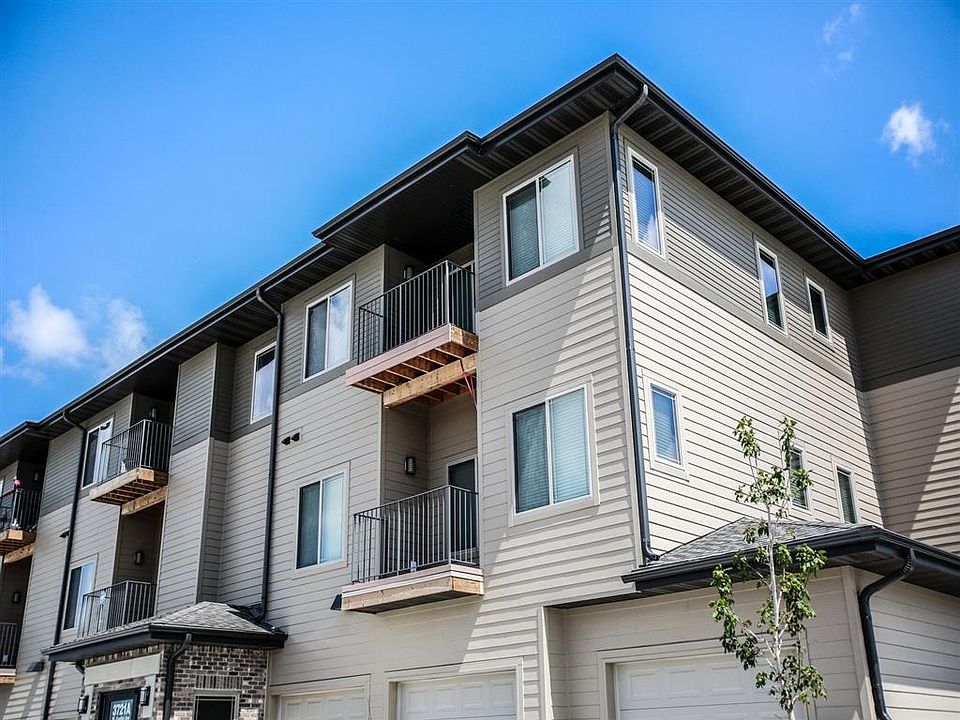 A modern apartment building with balconies and garages at The Sterling Grand Island.