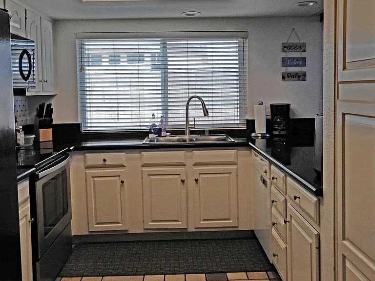 Updated kitchen fully stocked with cookware, dishes, utensils, and convenience appliances.