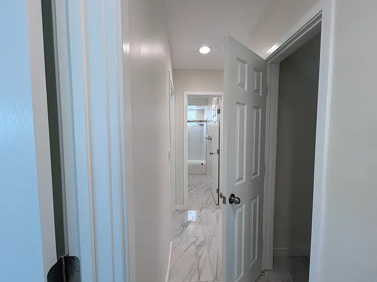 View from downstairs corridor: Downstairs bedroom (left); Downstairs bathroom (center): Under-stairs storage room (right)