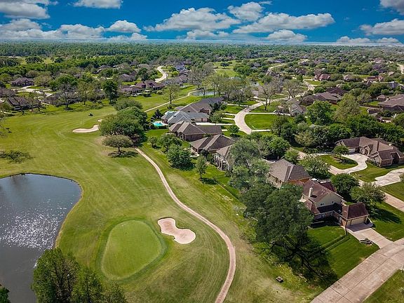 Here is a back aerial view of the property showing the gorgeous setting and the home's proximity to the 14th Green and Pond of t