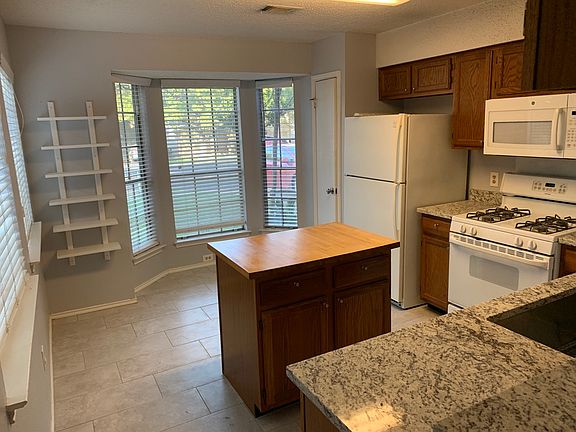 Dining nook of kitchen with shelving and pantry shown. Comes with built in microwave, refrigerator, range, dishwasher, and disposal.