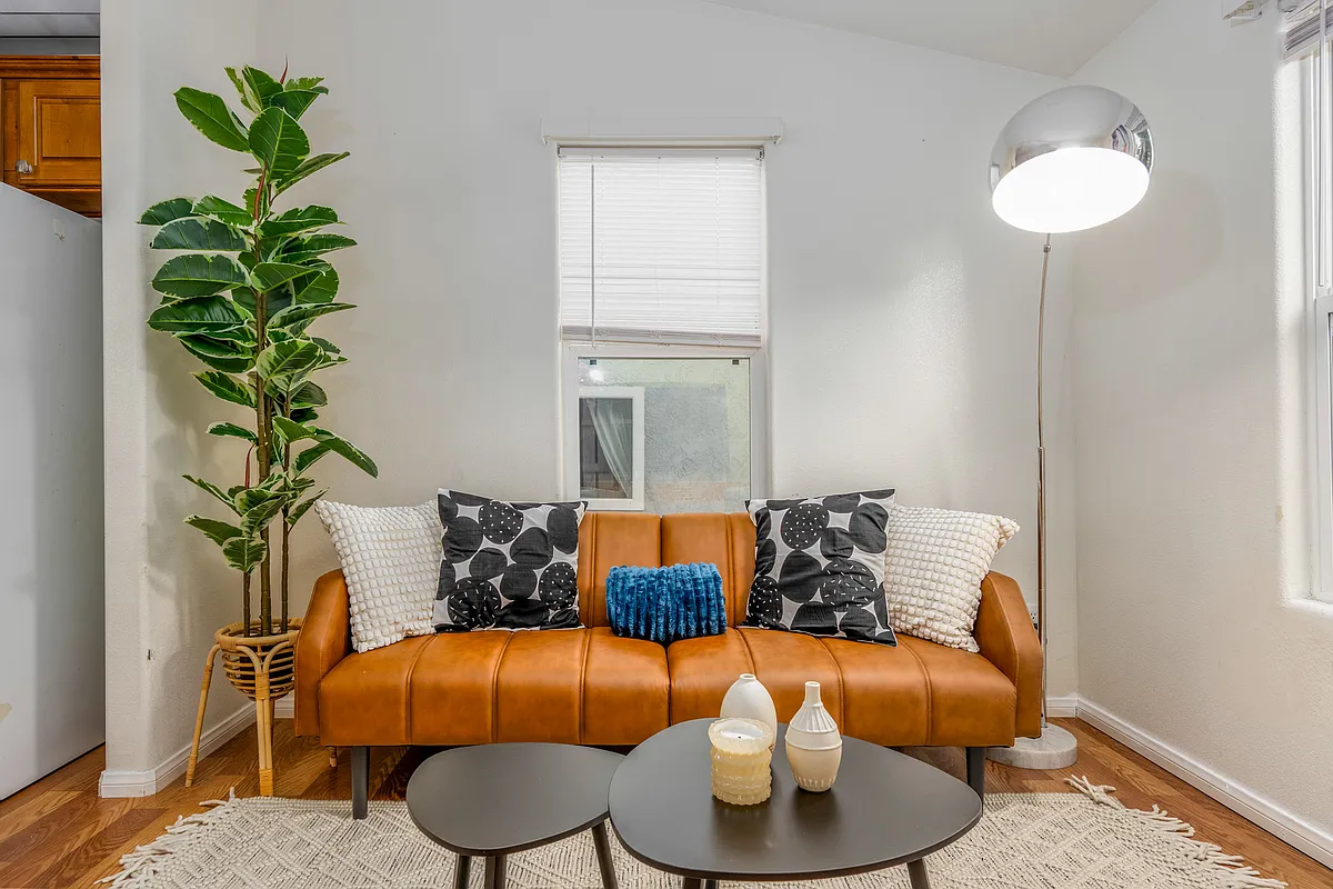 Caramel leather loveseat sits at the heart of the 2nd house living room - 732 Cotton St