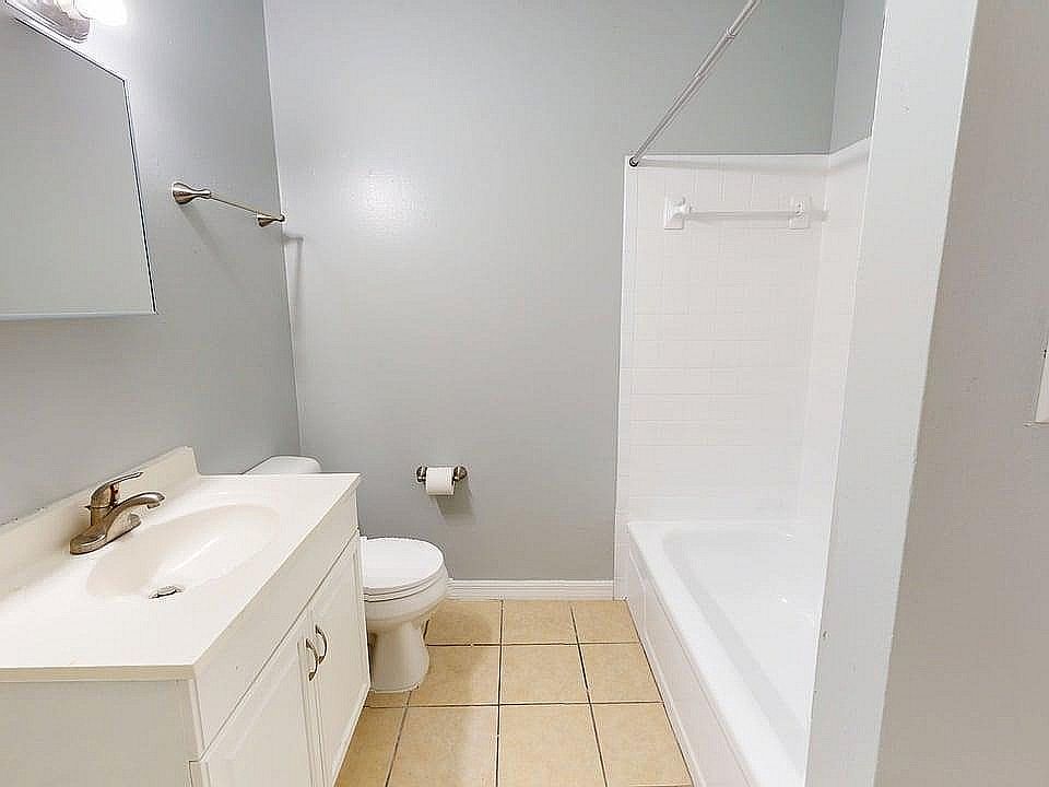 Bright and clean bathroom featuring a modern sink, toilet, and a pristine bathtub, optimized for comfort and style.