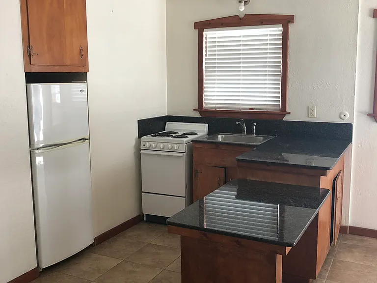 Kitchen with updated appliances, refrigerator built in for more space, granite counter tops and new tile flooring.