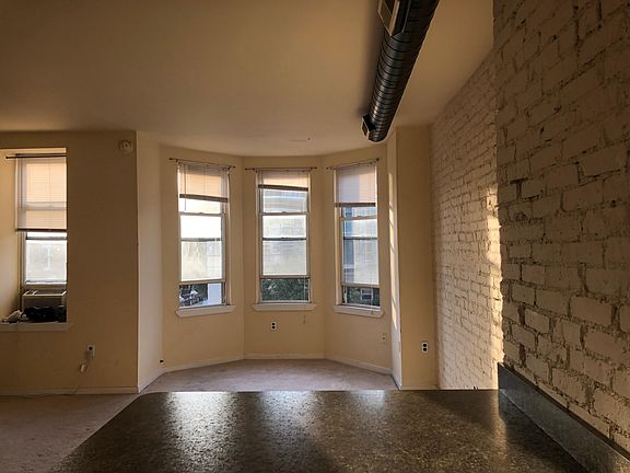 VIEW OF LIVING ROOM WITH OFF WHITE CARPETING AND BAY WINDOW