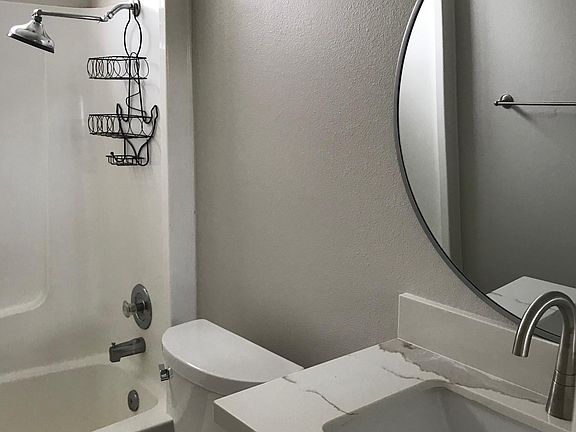 Upstairs bathroom freshly painted with new tile plank flooring. New cabinet, sink & fixtures, quartz countertop, mirrors and toilet.