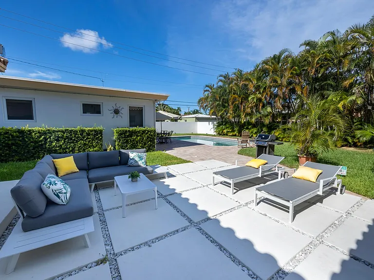 Double sized private fully fenced lot with patio, outdoor dining table, and heated pool.