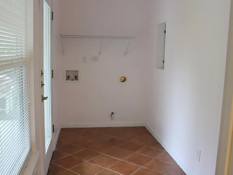 Utility room with door to covered back porch. Washer/dryer now provided.