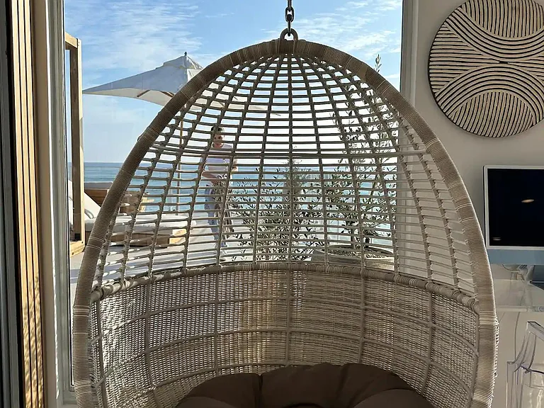 Find tranquility in the hanging chair, suspended relaxation with a view that whispers serenity.