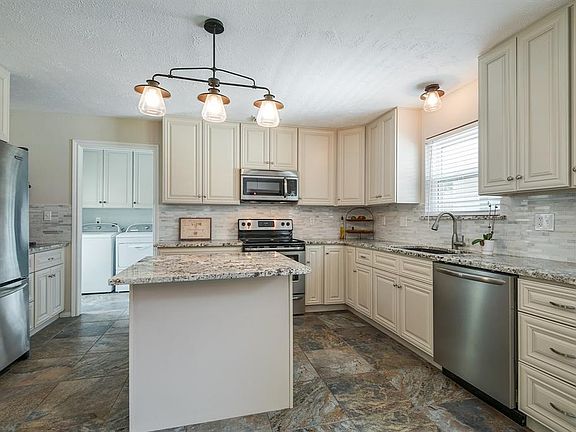RENOVATED KITCHEN HAS ALL NEW CABINETS IN SUMMER, 2016 -- GRANITE COUNTERS, GRANITE SINK, GLASS TILE BACKSPLASH, STAINLESS APPLIANCES, UPDATED LIGHTING.
