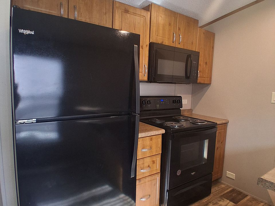 "Kitchen features a stove, refrigerator, and microwave for everyday convenience."