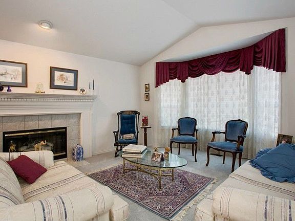 Elegant living room has tile surround fireplace and beautiful bay window overlooking front yard!