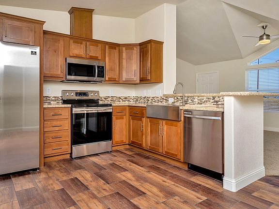 Kitchen - Solid wood cabinets, upgraded nickel hardware, title back splashes, highly upgraded stainless appliance package, center island, and country farm sink with pull-out faucet, recessed lighting.