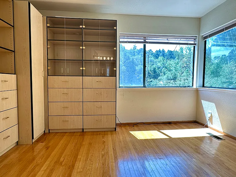 Primary bedroom with dressers in addition to the closet. View of the hills.