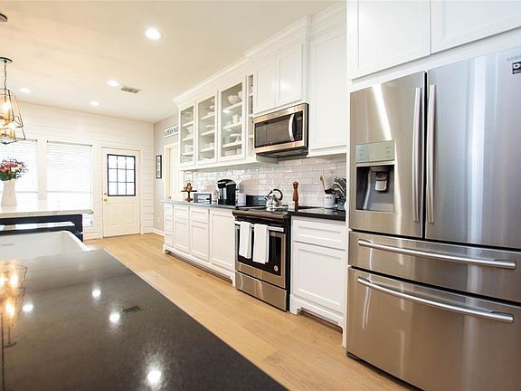 Custom cabinets accent the subway tile and SS appliances