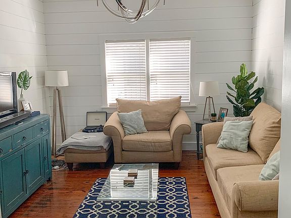 The nice sized living room with heart pine flooring and shiplap walls.
