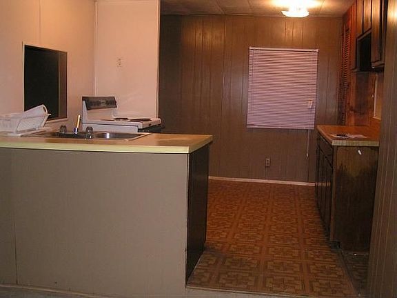 Kitchen-no appliances included. View from dinig room-open to den.