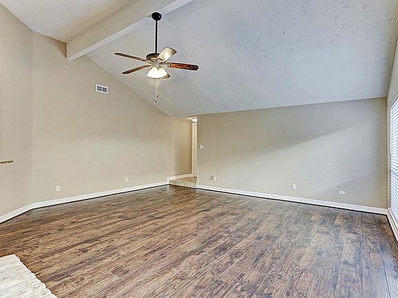 Spacious family den with high ceilings and hard surface flooring.