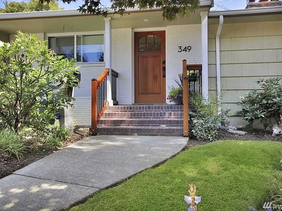 Beautiful custom brick entry and railing, painted brick exterior, and new front door, all add a modern look to this classic 50's home.