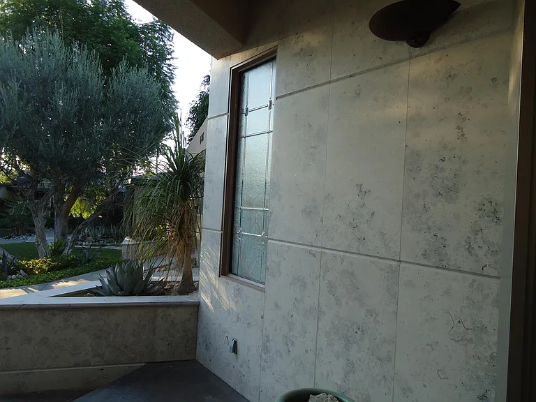 Jurastone veneer surrounds home and tennis court