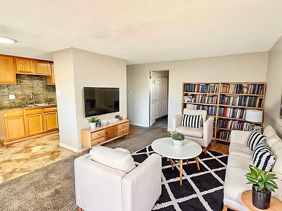 Inviting living room with cozy seating, stylish decor, and integrated kitchen area, perfect for relaxation and social gatherings.