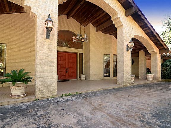 Double stockade style front doors are inset beneath the grand covered front Porch that soars to over 20-feet in height and over 60-feet in width and is finished with rough sawn timber.