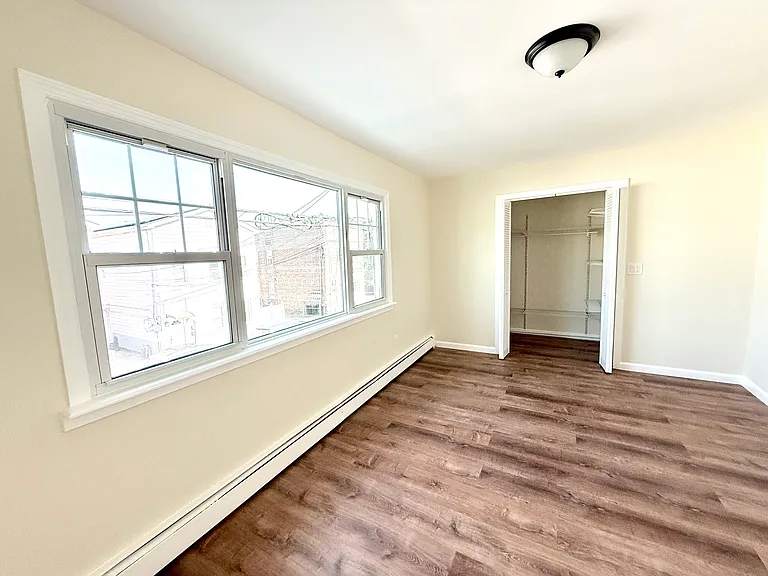 Primary bedroom with large window and walk-in-closet