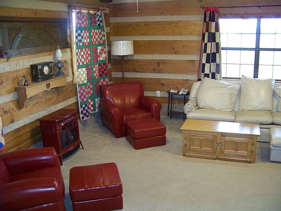 Sitting room or library is enclosed by glass doors.