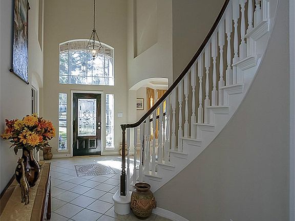 Grand entry with spiral staircase and tall ceilings.