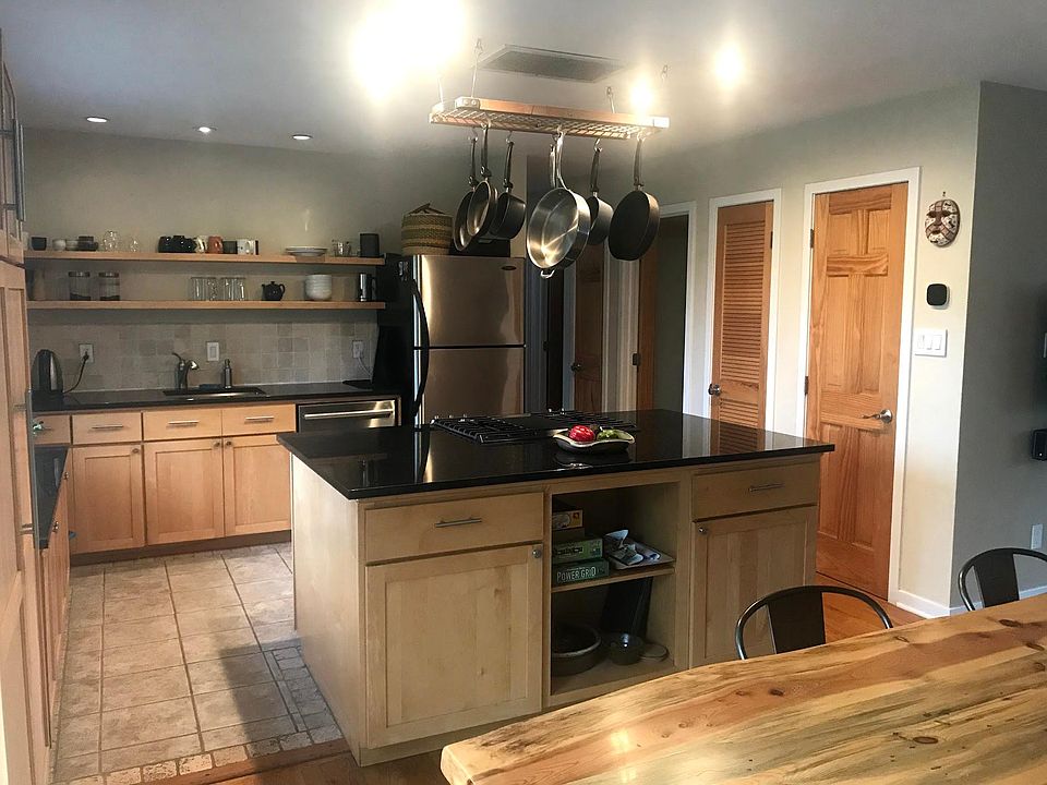 Kitchen with maple cabinets and granite countertops and large island with gas stove.