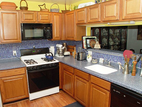 Kitchen features hardwood floor and Corian counters and opens to the DR