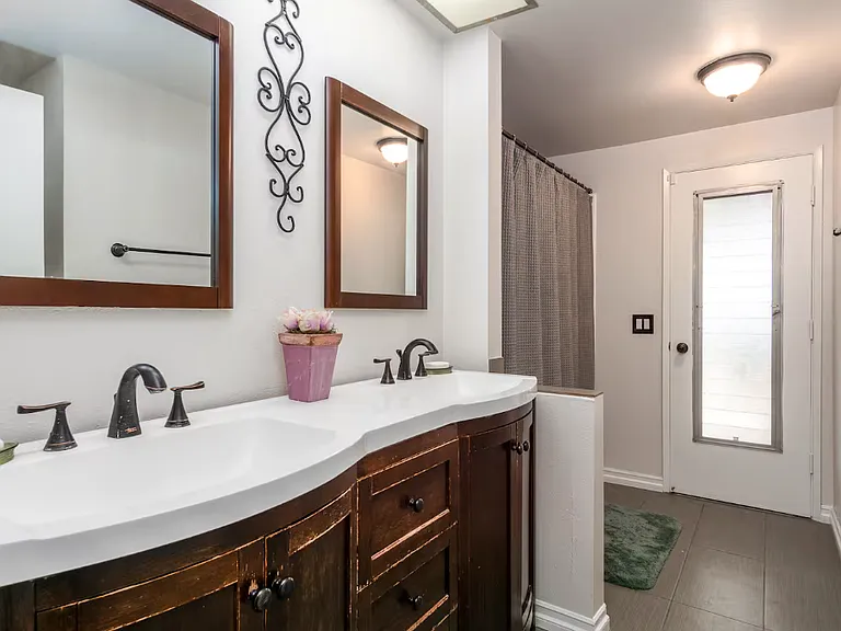 This is the 2nd bathroom. It is newly renovated. It has a he/she sink, toilet and bathtub with shower.