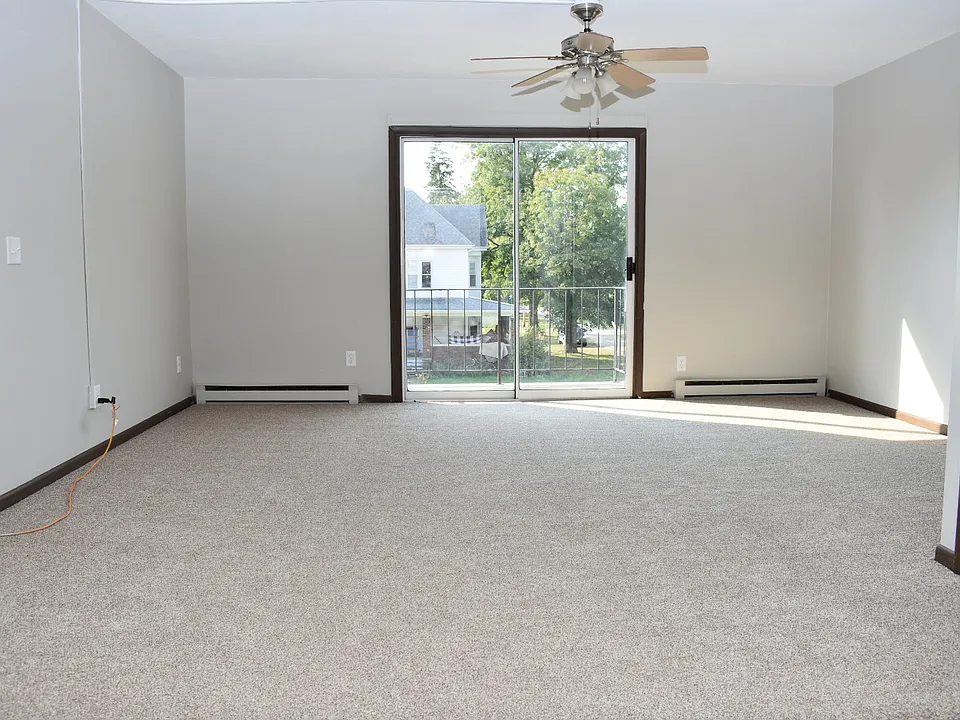 Large, bright living room with small patio and new carpet