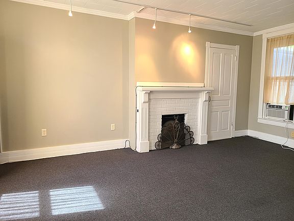 Living Room with electric fireplace, bookcase and closet.